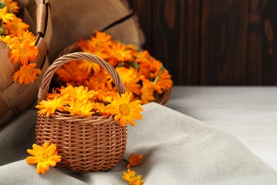 Beautiful fresh calendula flowers on table, space for text