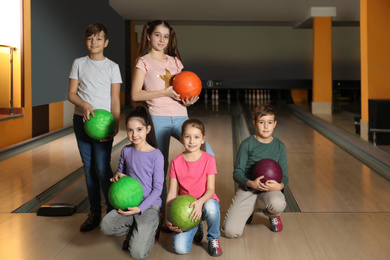 Photo of Happy children with balls in bowling club