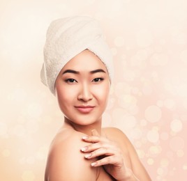 Beautiful young Asian woman with silky skin on light background. Spa treatment 
