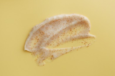 Sample of face scrub on yellow background, top view