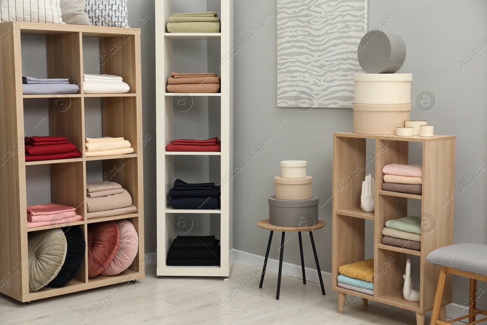 Photo of Different colorful bed linens and decorative boxes on display in home textiles store