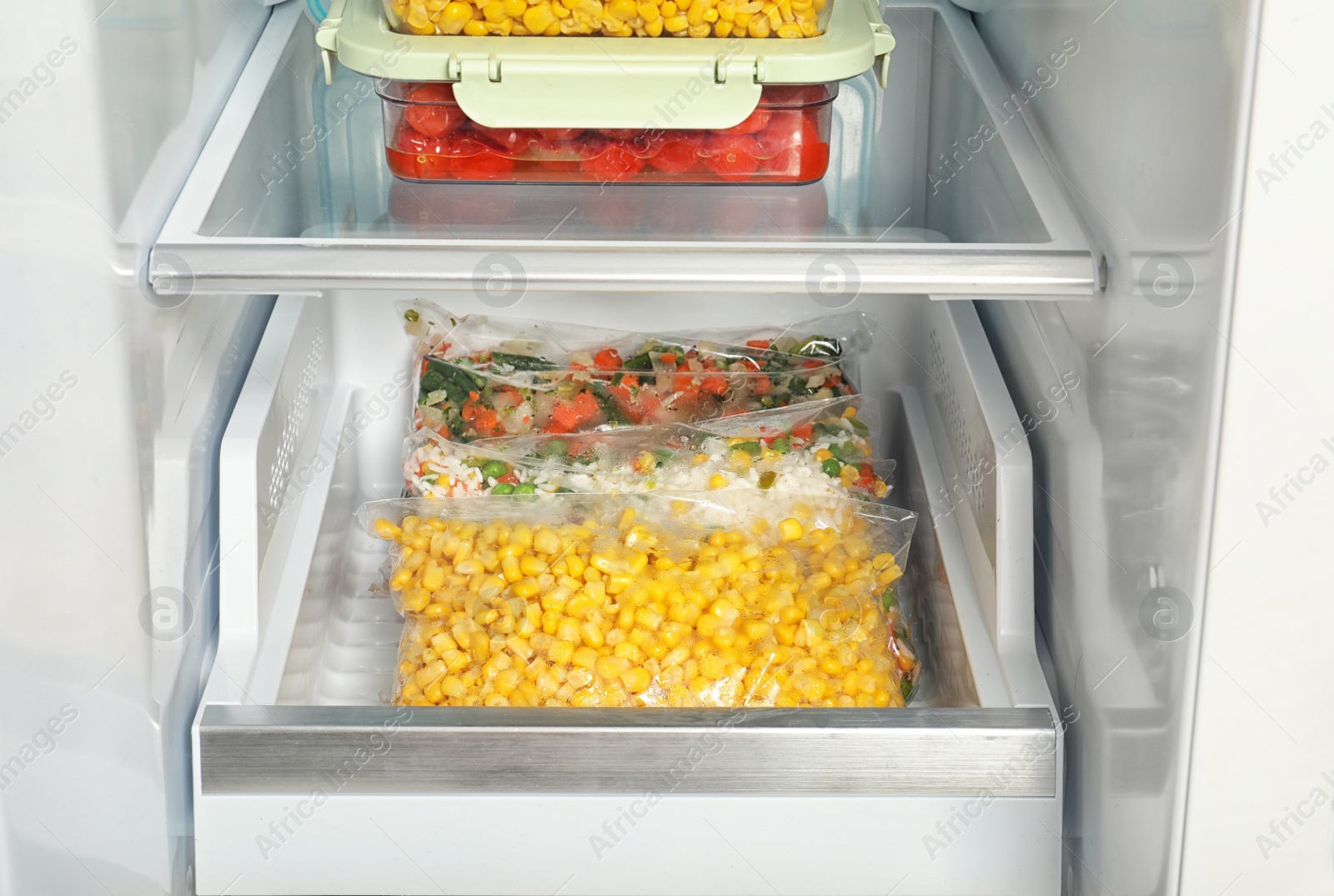 Photo of Bags with frozen vegetables in modern refrigerator