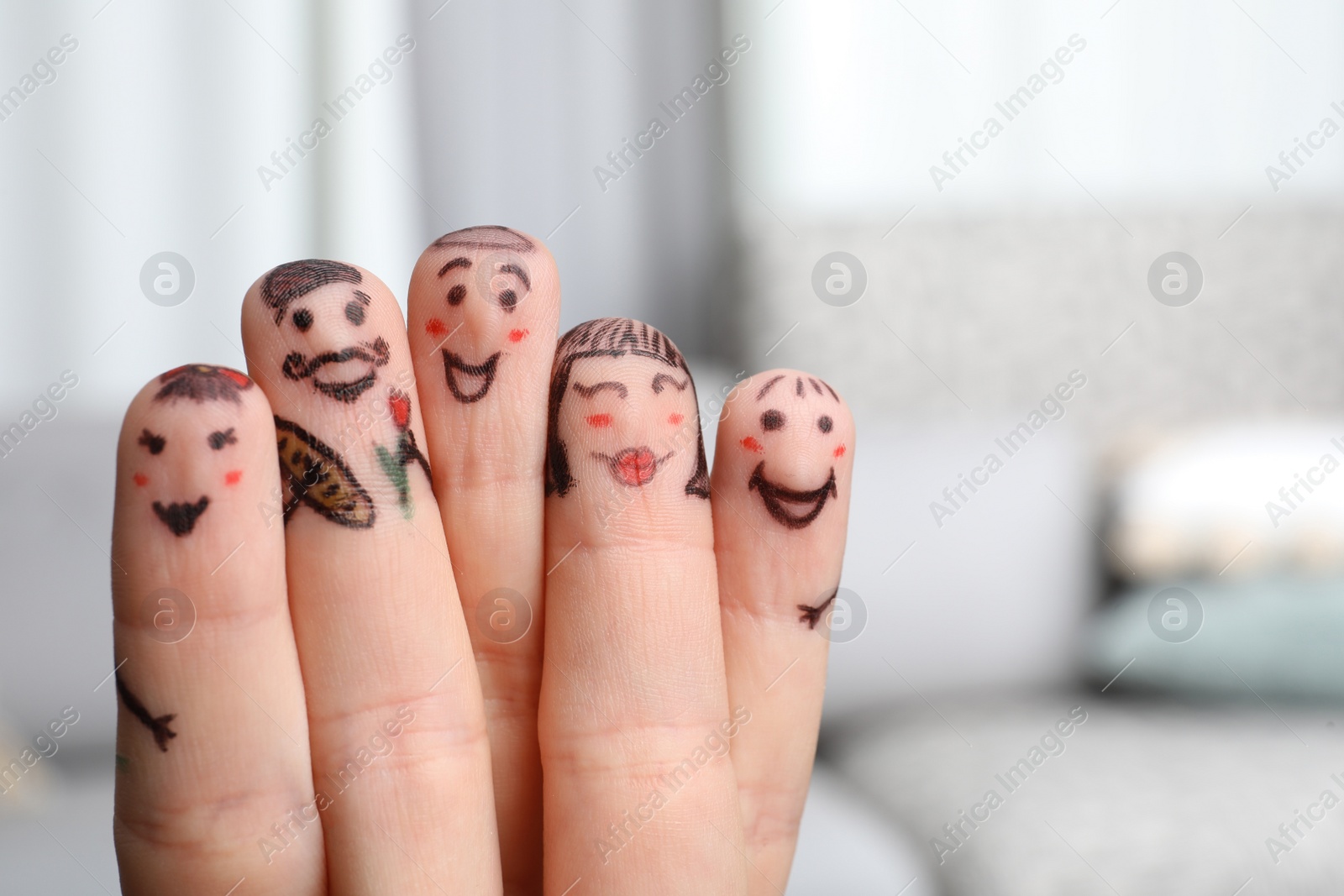 Photo of Five fingers with drawings of happy faces on blurred background