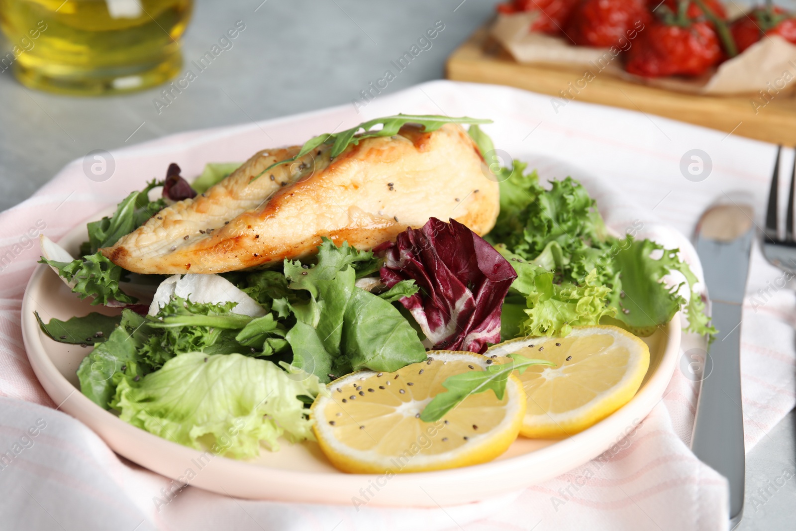 Photo of Delicious cooked chicken and fresh salad served on table, closeup. Healthy meals from air fryer