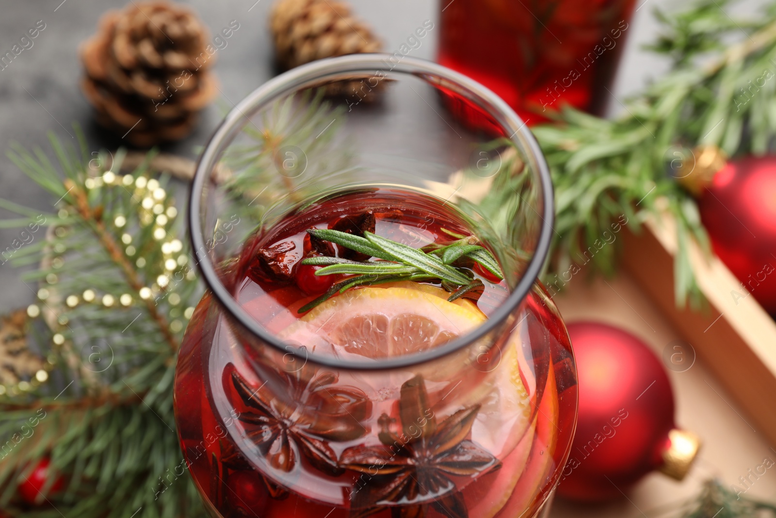 Photo of Aromatic punch drink and Christmas decor on table, closeup