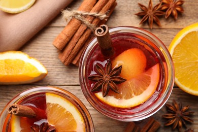 Photo of Aromatic punch drink and ingredients on wooden table, flat lay