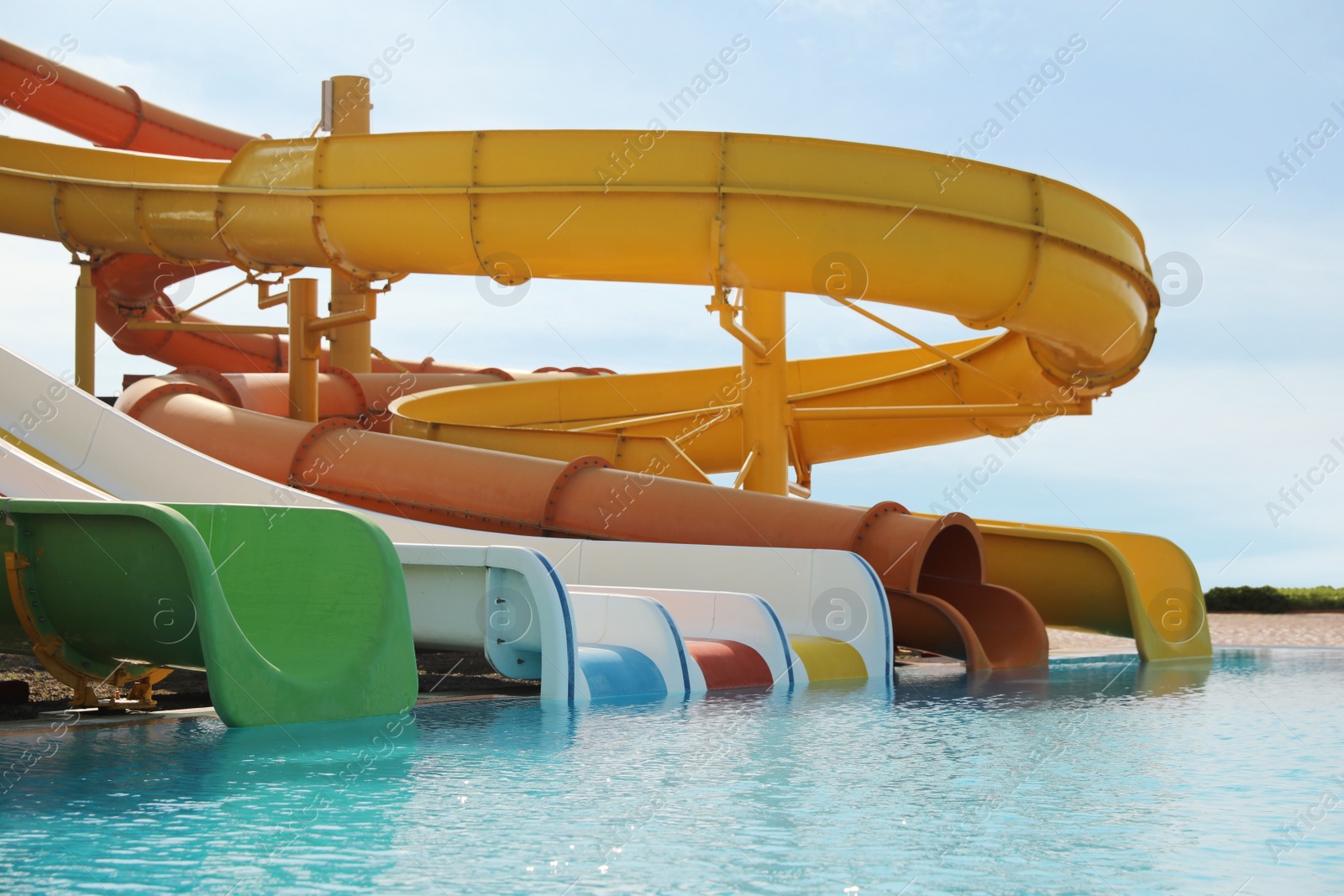 Photo of Beautiful view of water park with colorful slides and swimming pool on sunny day