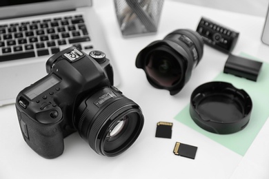 Photo of Equipment for photographer on table, focus on professional camera