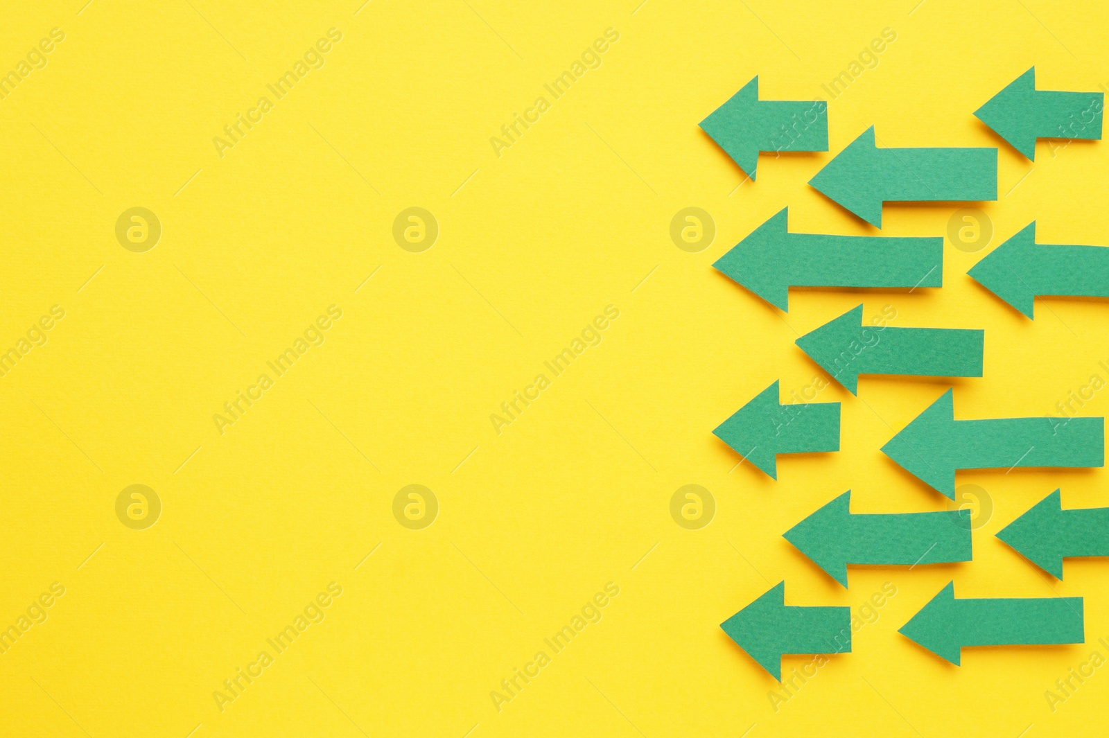 Photo of Paper arrows on yellow background, flat lay. Space for text