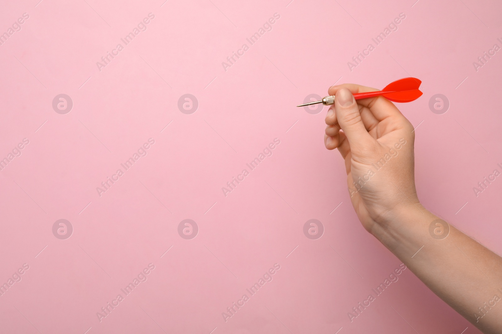 Photo of Woman holding red dart arrow on pink background, closeup with space for text