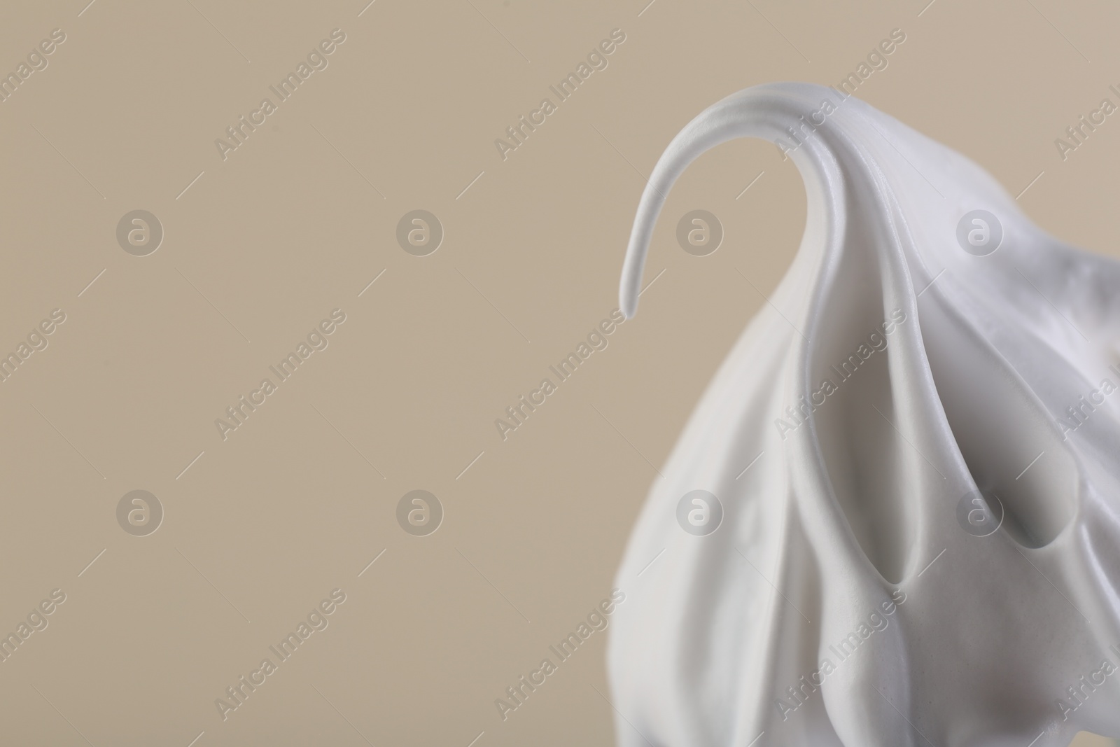 Photo of Whipped cream on beige background, closeup. Space for text