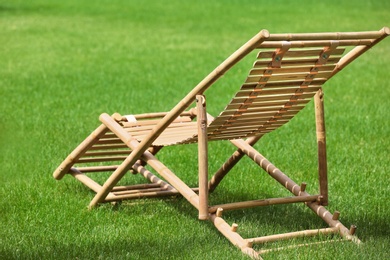 Wooden deck chair in beautiful garden on sunny day