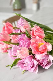 Beautiful bouquet of colorful tulip flowers on white table indoors