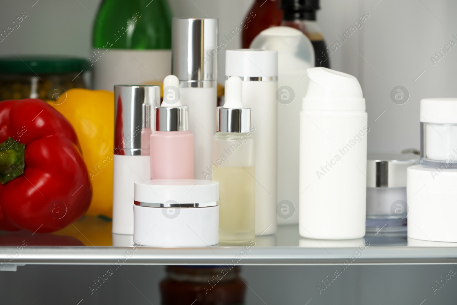 Photo of Different cosmetic products on shelf in refrigerator