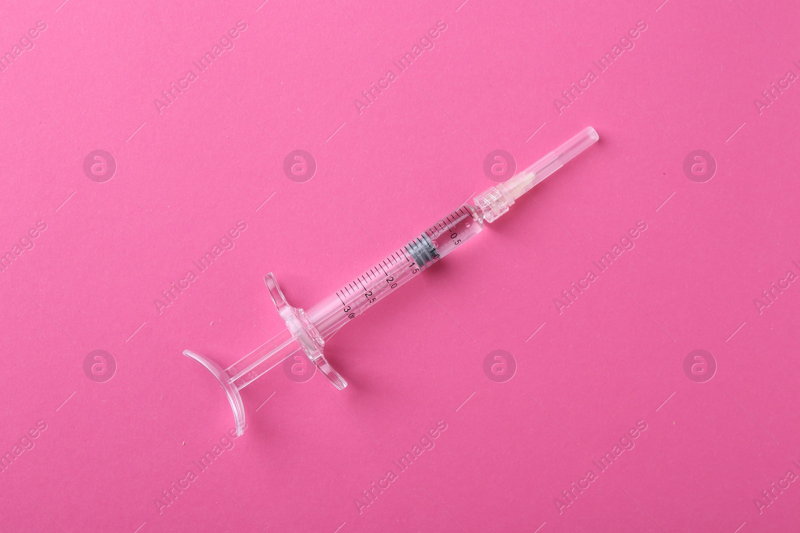 Photo of Injection cosmetology. One medical syringe on pink background, top view