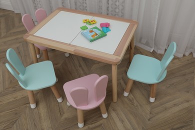 Photo of Small table and chairs with bunny ears in children's room