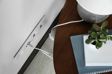Electric power outlet sockets with charger on white wall, above view