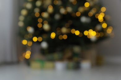 Photo of Blurred view of Christmas tree and gifts indoors