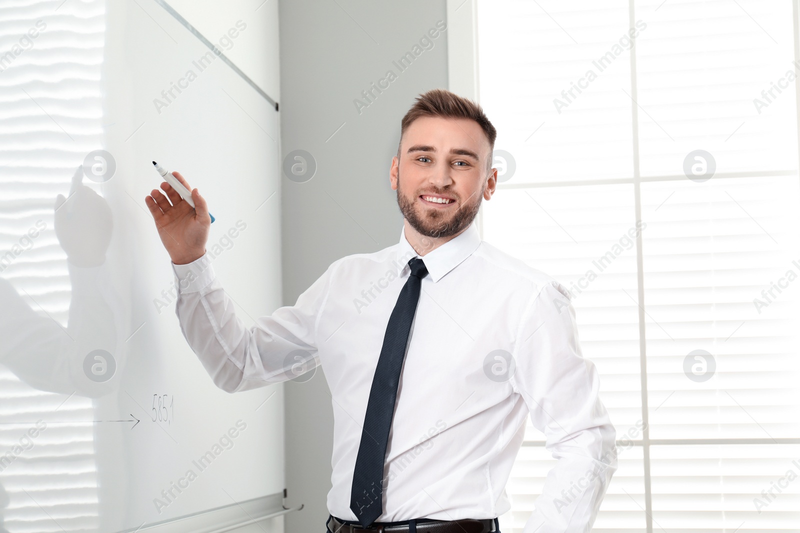 Photo of Professional business trainer near whiteboard in office