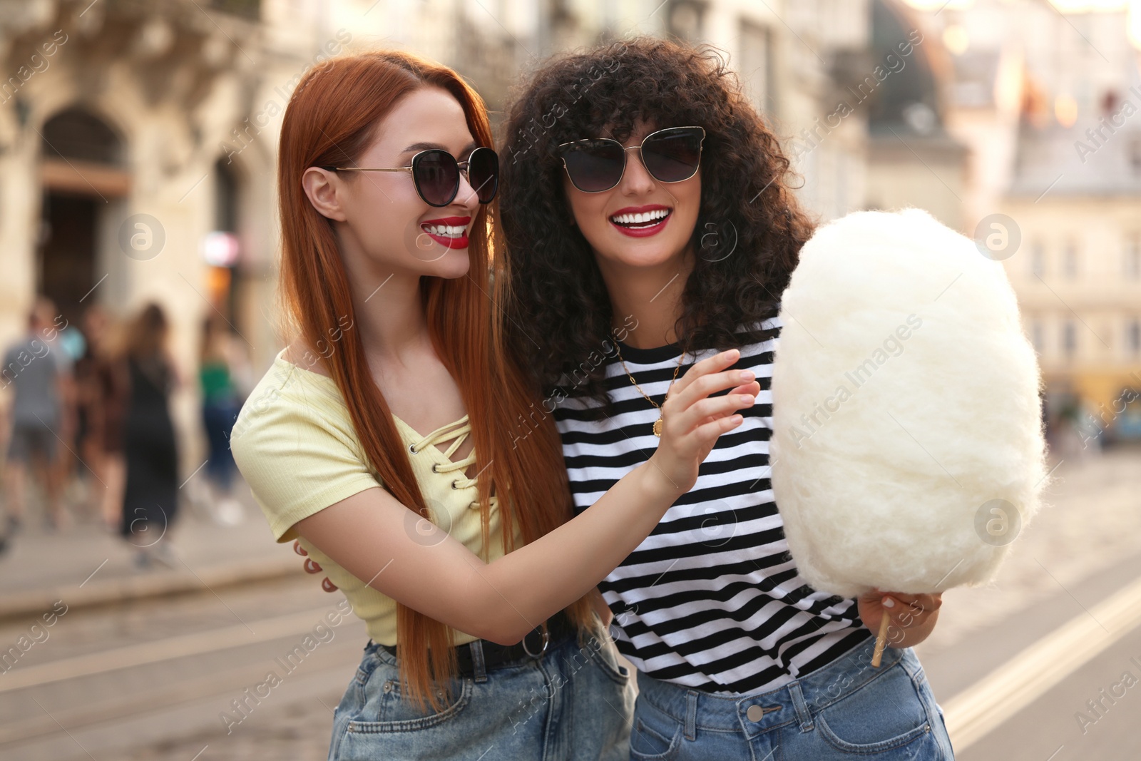 Photo of Happy friends with cotton candy on city street