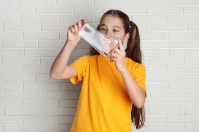 Photo of Preteen girl with slime near white brick wall