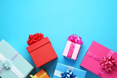 Photo of Many colorful gift boxes on light blue background, flat lay. Space for text