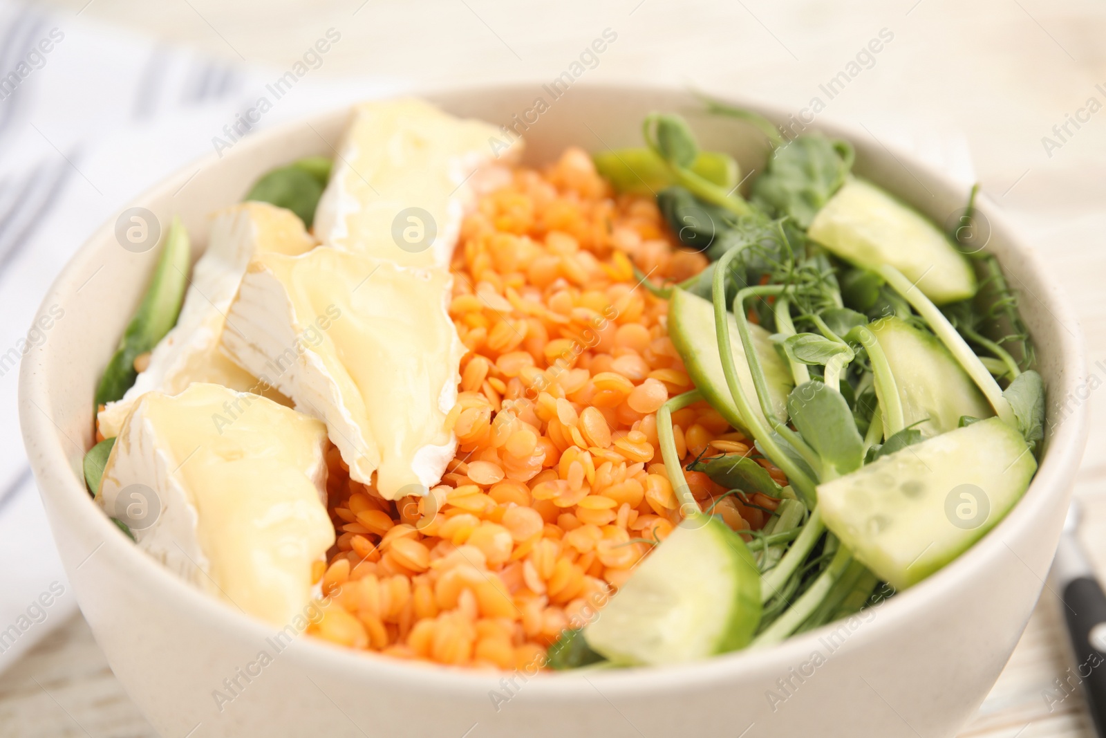 Photo of Delicious lentil bowl with soft cheese and cucumber, closeup