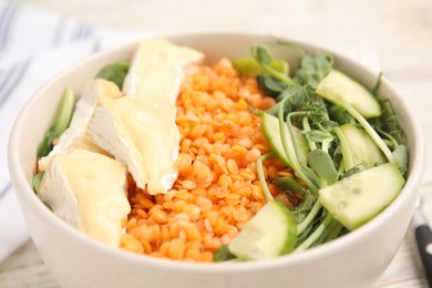 Delicious lentil bowl with soft cheese and cucumber, closeup