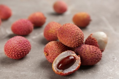 Photo of Fresh ripe lychee fruits on grey table
