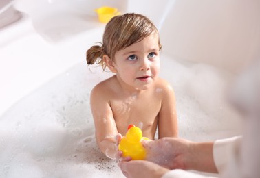 Mother playing with her little daughter in bath tub, closeup