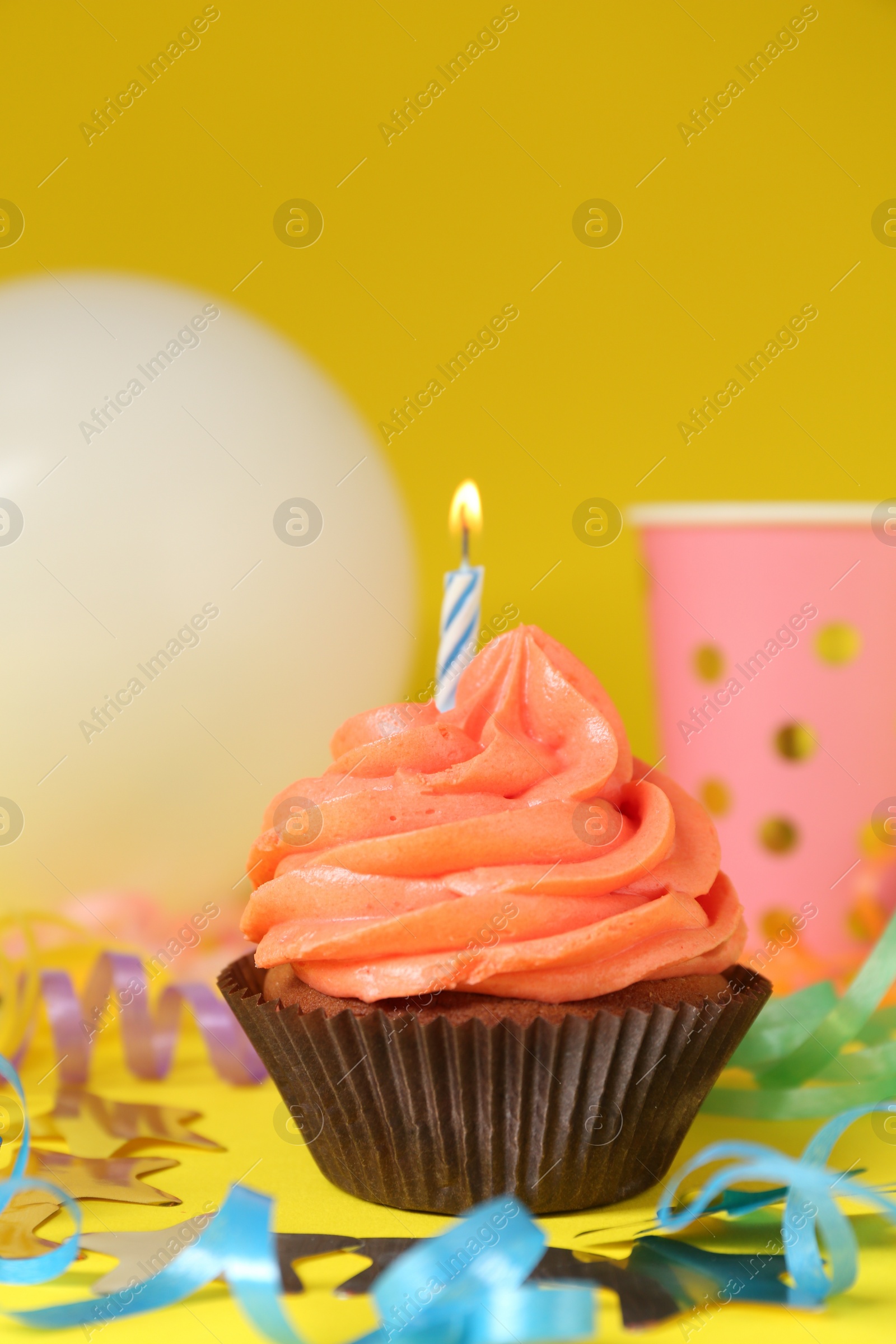 Photo of Delicious birthday cupcake with bright cream on yellow background