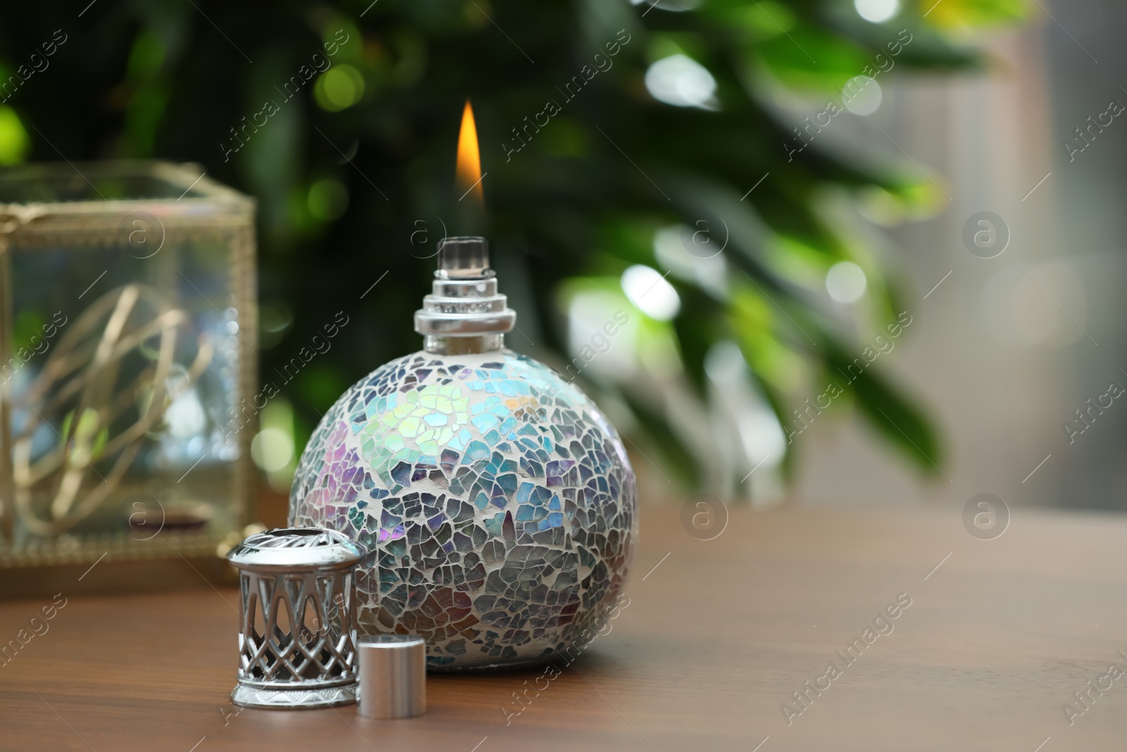 Photo of Burning catalytic purifying lamp on wooden table, space for text. Interior element