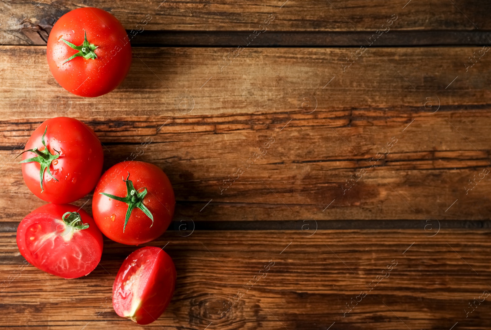 Photo of Fresh ripe tomatoes on wooden table, flat lay. Space for text