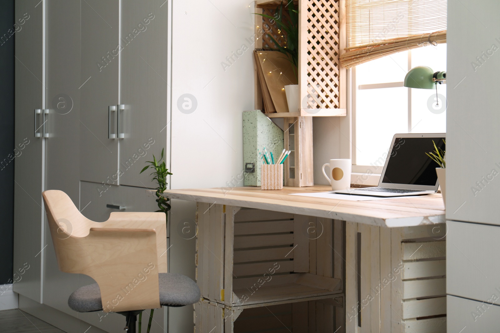 Photo of Modern home workplace with wooden crates. Eco style interior