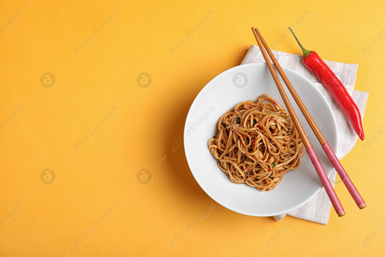 Photo of Cooked noodles served on orange background, flat lay. Space for text