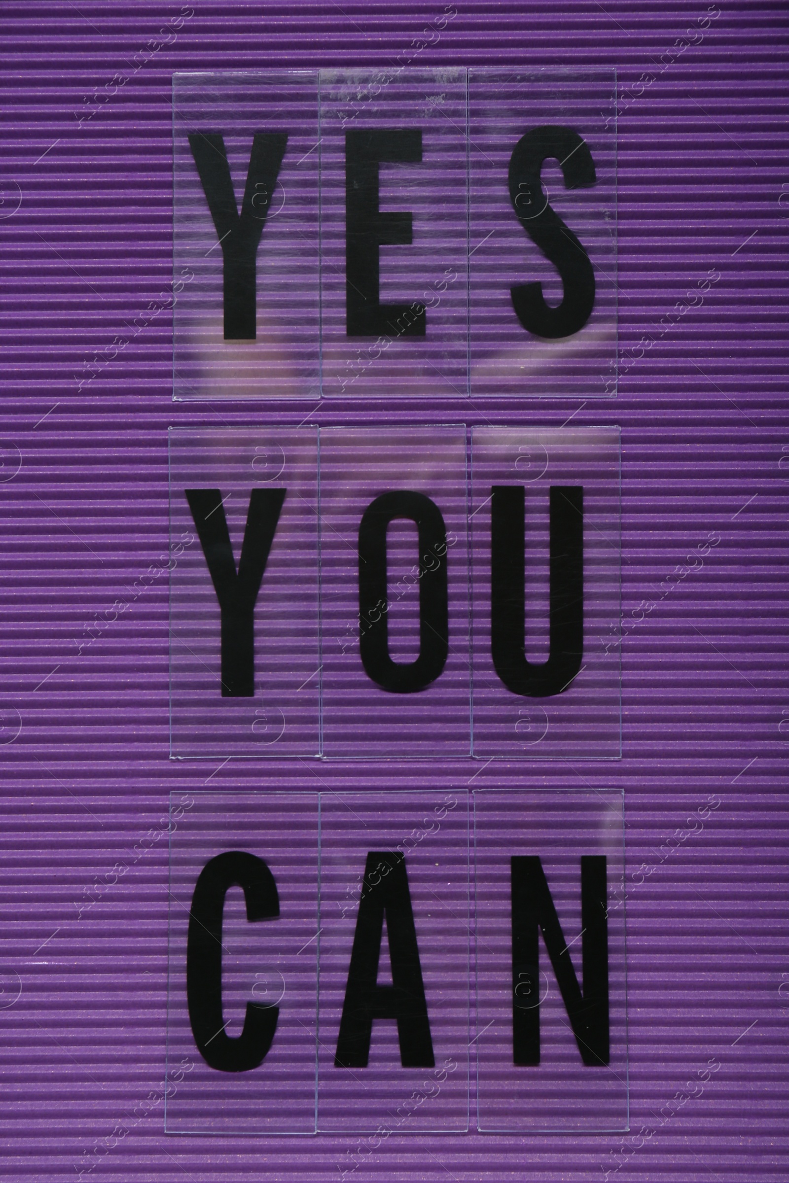 Photo of Phrase Yes You Can of plastic letters on purple background, top view. Motivational quote