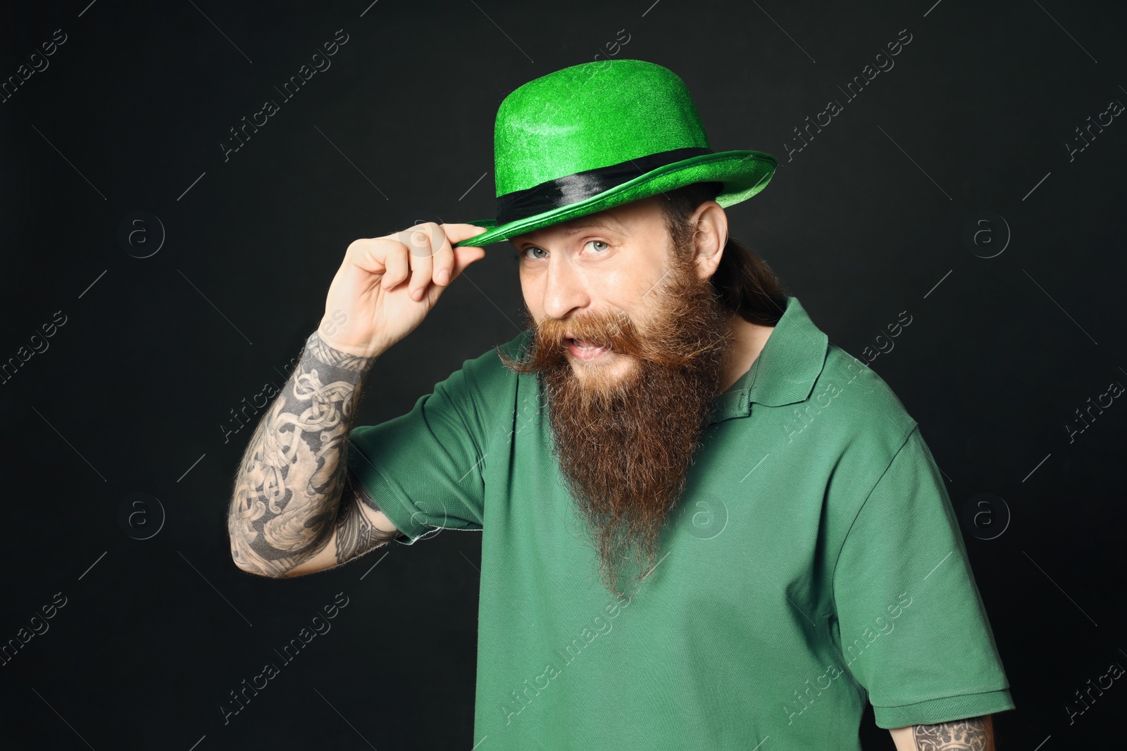 Photo of Bearded man in green hat on black background. St. Patrick's Day celebration