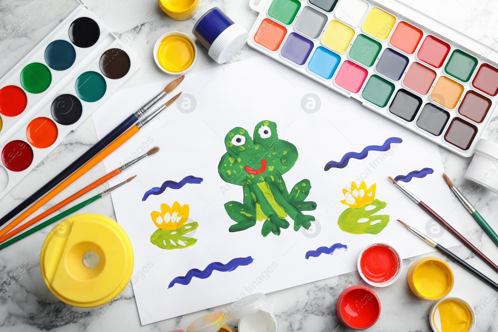 Photo of Flat lay composition with child's painting of frog on white marble table