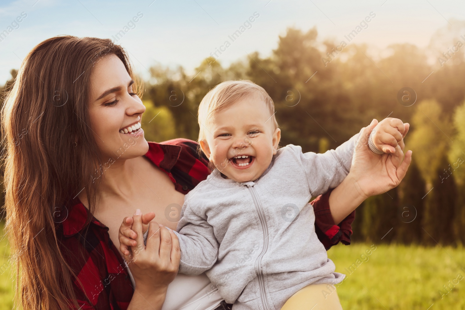 Image of Happy mother with her cute baby in park on sunny day