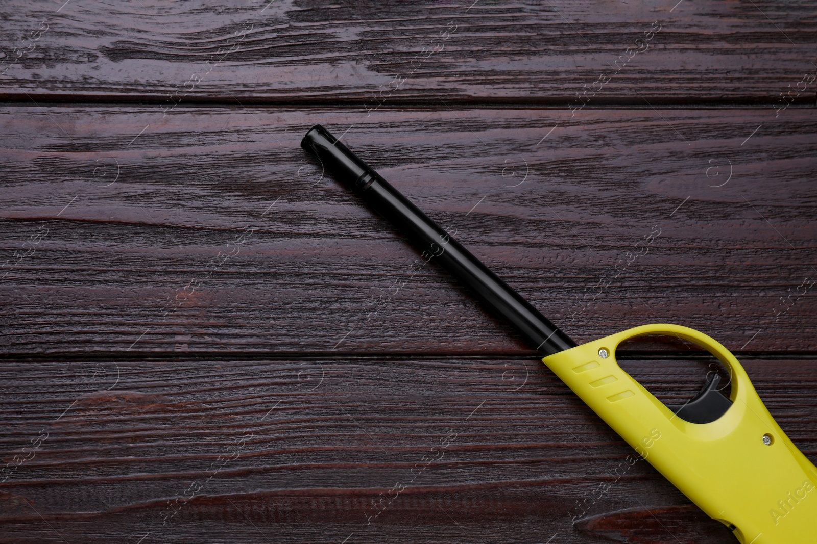 Photo of One gas lighter on wooden table, top view. Space for text