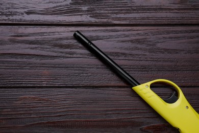 One gas lighter on wooden table, top view. Space for text