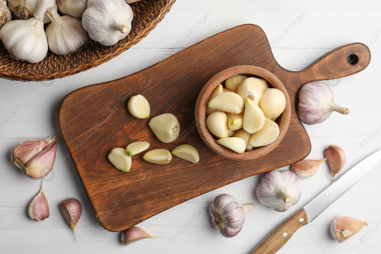 Photo of Fresh organic garlic on white wooden table, flat lay