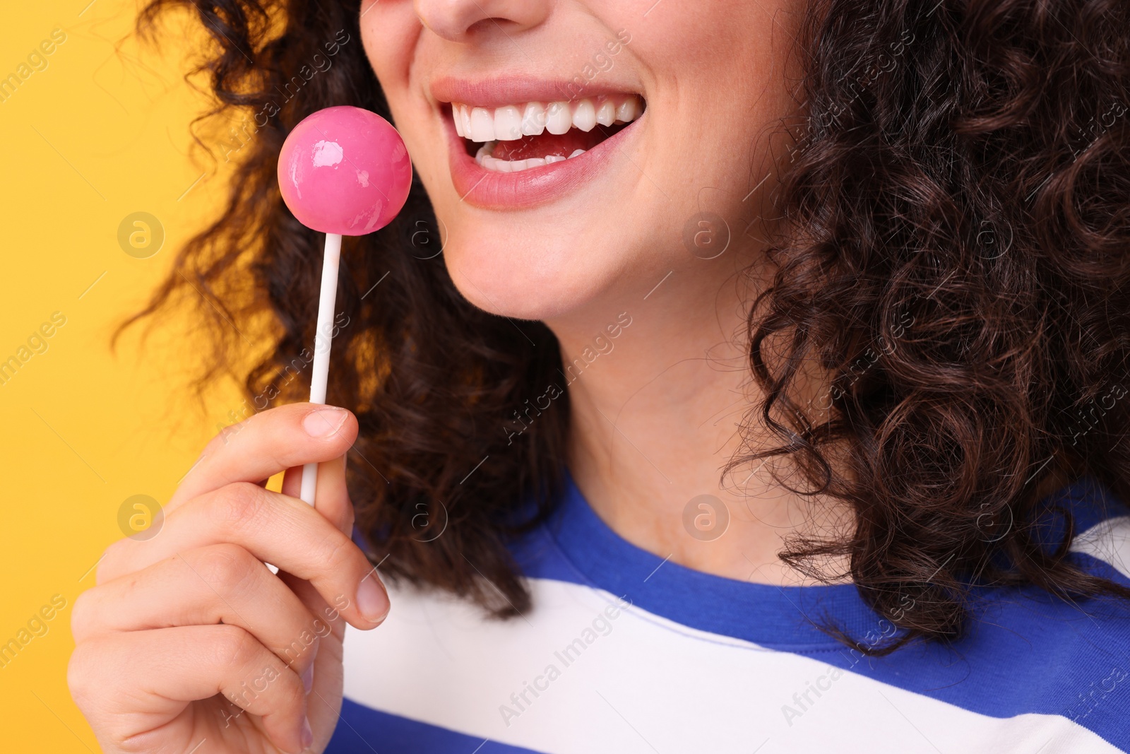 Photo of Woman with lollipop on yellow background, closeup