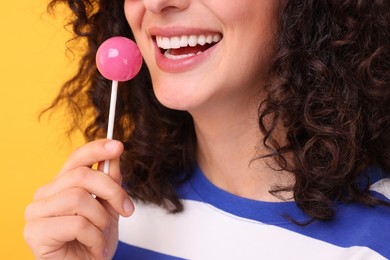 Photo of Woman with lollipop on yellow background, closeup
