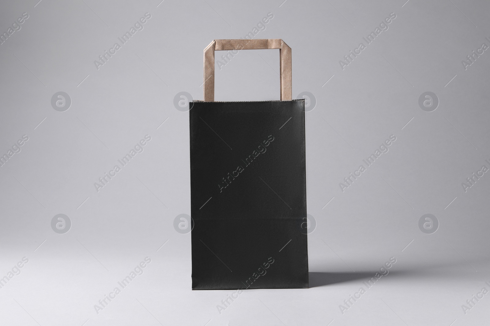 Photo of Black paper bag on light grey background