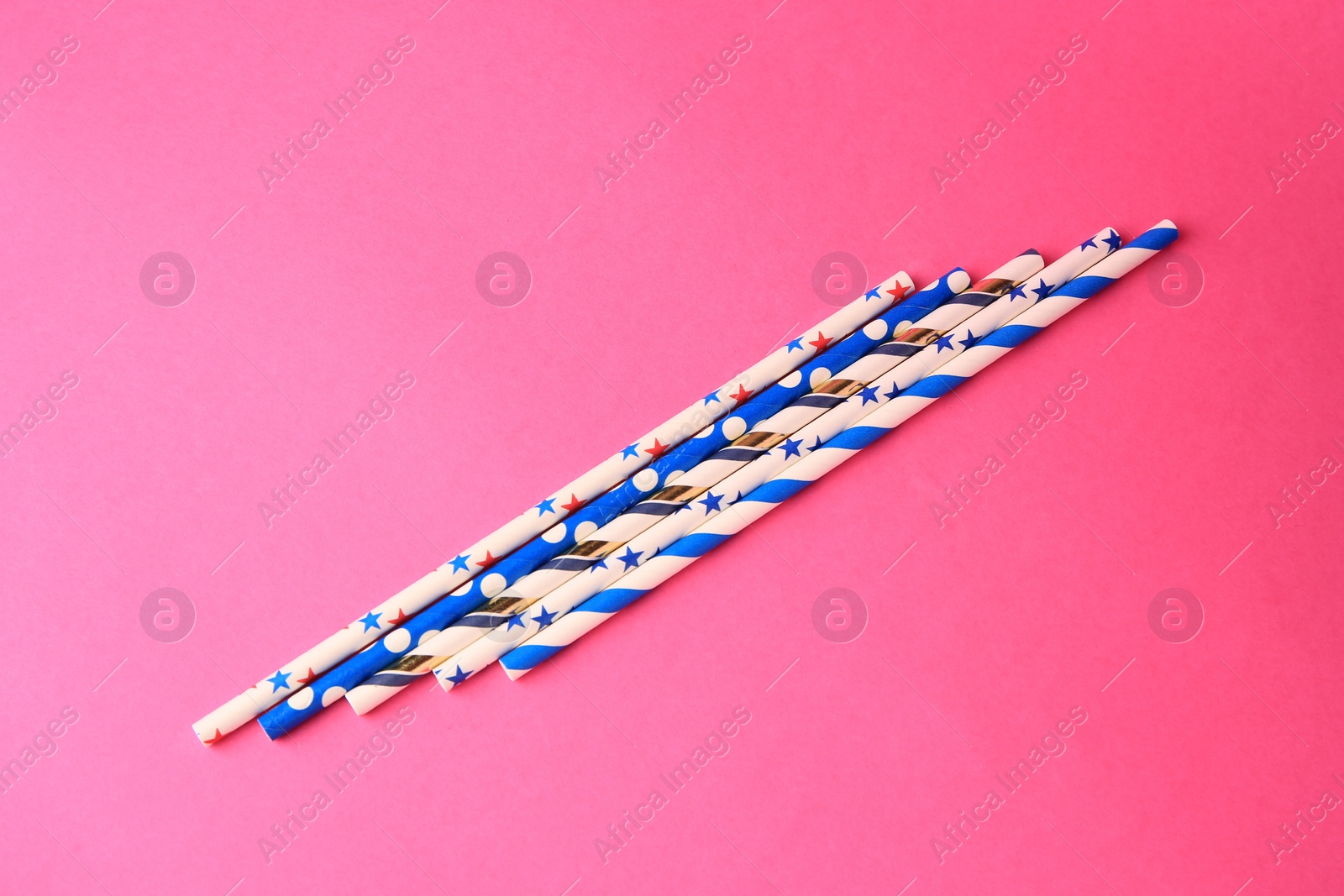 Photo of Paper drinking straws on pink background, flat lay