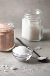 Photo of Different natural salt on grey table, closeup