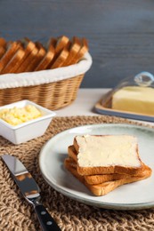 Photo of Tasty toasts served with butter on white wooden table