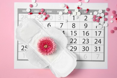 Flat lay composition with calendar, menstrual pad and pills on color background. Gynecological checkup