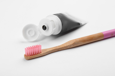 Photo of Bamboo toothbrush and charcoal paste isolated on white